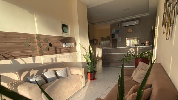 Amplia sala de estar con un conjunto de sofás, una mesa de centro y plantas en macetas.