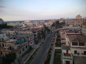 A cityscape with a wide street, historic buildings, and a prominent tower. - Casa Issi Nelson (Havana)