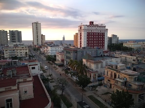 A cityscape with various buildings, including a prominent red and white building with a sign that reads "Hotel Presidente." - Casa Issi Nelson (Havana)