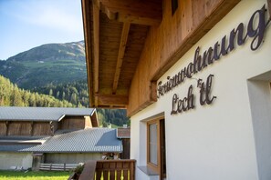 A building with a sign reading "Gasthof zur Post" and a view of a mountain landscape.