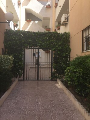 Enter a serene oasis through this beautifully landscaped entrance, surrounded by lush greenery and a modern architectural design.
