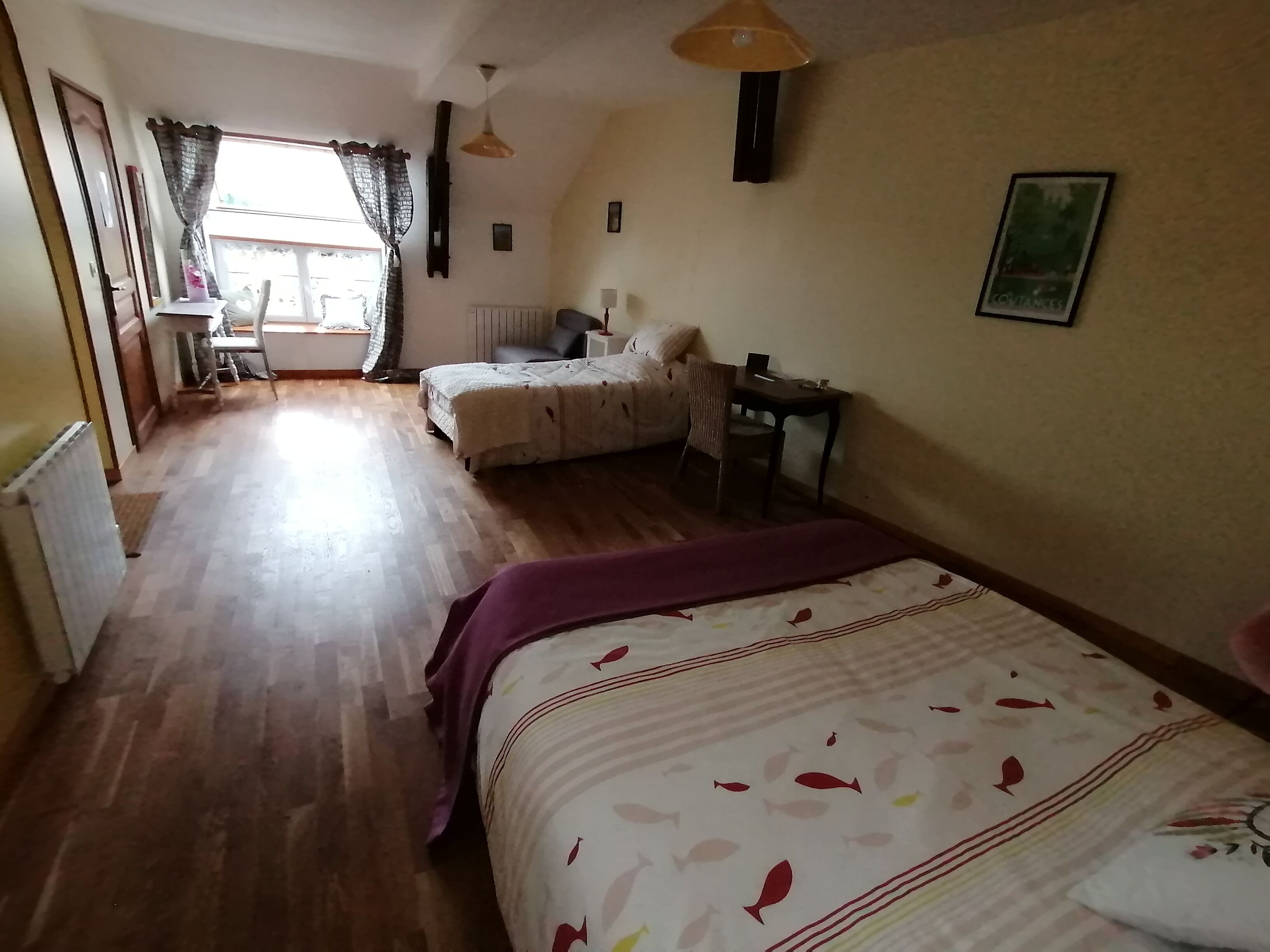 Un dormitorio con cama, escritorio, silla y radiador.