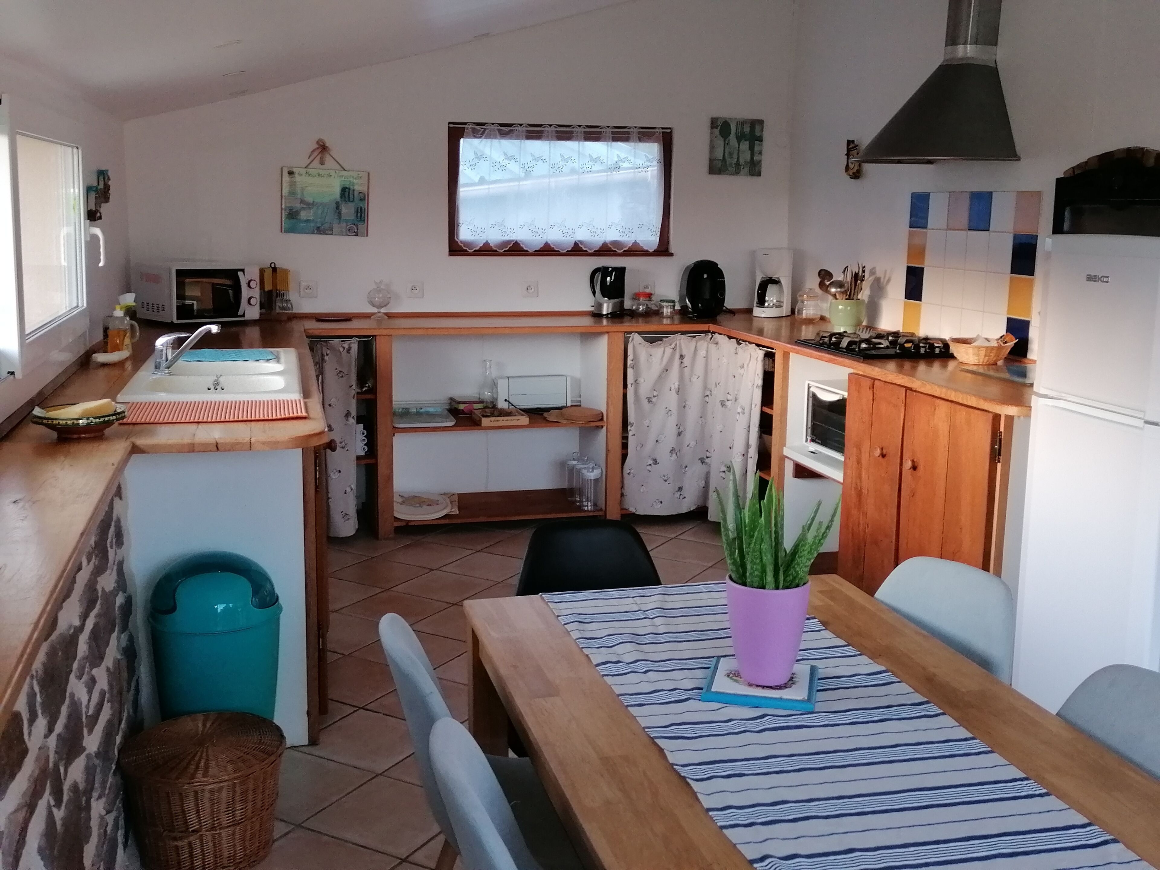 Cocina compacta con lavabo, estufa y zona de comedor.