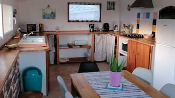 Une cuisine de taille réduite comprenant un évier, une cuisinière et un coin repas.