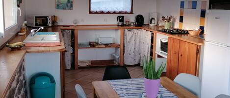 Cocina compacta con lavabo, estufa y zona de comedor.