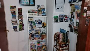 Una habitación con una pared blanca que incluye un calendario, una pizarra y varios folletos de viajes.