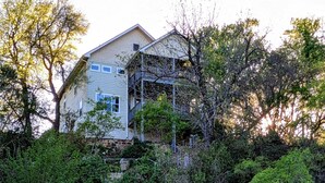 A two-story house with a stone staircase leading up to a balcony.