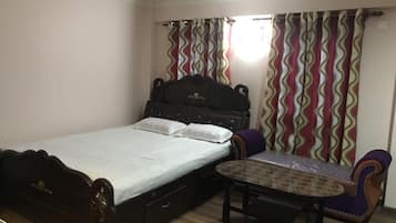 Una camera da letto con un letto, un comodino e una sedia.