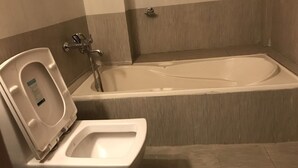 Een badkamer met een toilet en een bad.