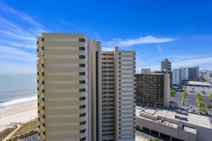 A high-rise building with a modern architectural design, featuring a series of balconies and a flat facade.