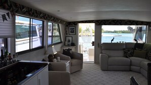 A boat interior with a living area, a bar, and a view of the water. - TRAVEL THE KEYS OR JUST RELAX AT THE DOCK (Key West)