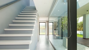 A modern staircase with white steps leading to a glass door. - Modern Villa with Unique Architecture & Captivating Sunsets (Skouloufia)