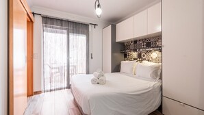 Habitación de hotel con cama, armario y cabecera estampada.