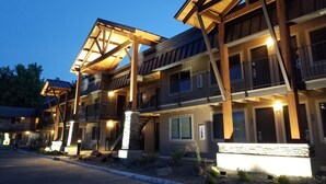 A multi-story hotel with a wooden exterior, balconies, and a well-lit entrance. - The Hotel Y, a Dazzler Select by Wyndham (Yakima)
