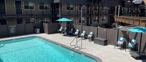 Una piscina al aire libre de temporada, sombrillas