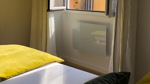 A hotel room with a large window offering a view of a historic building with a bell tower. - Beautiful Apartment ! Historic District Bastia (Bastia)