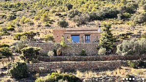 A stone house with a tiled roof, surrounded by dry vegetation and trees on a hillside. - Villa CALIMA in Benissa – 3 bedrooms, private pool, sea and mountain views, Wi-Fi and private parking (Benissa)