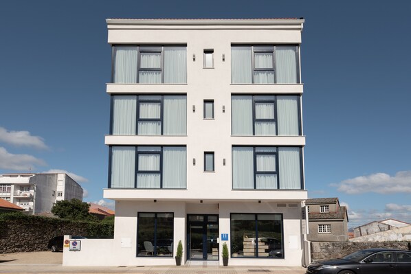 A modern multi-story building with large windows and a flat roof. - Hotel Costa da Morte (Fisterra)