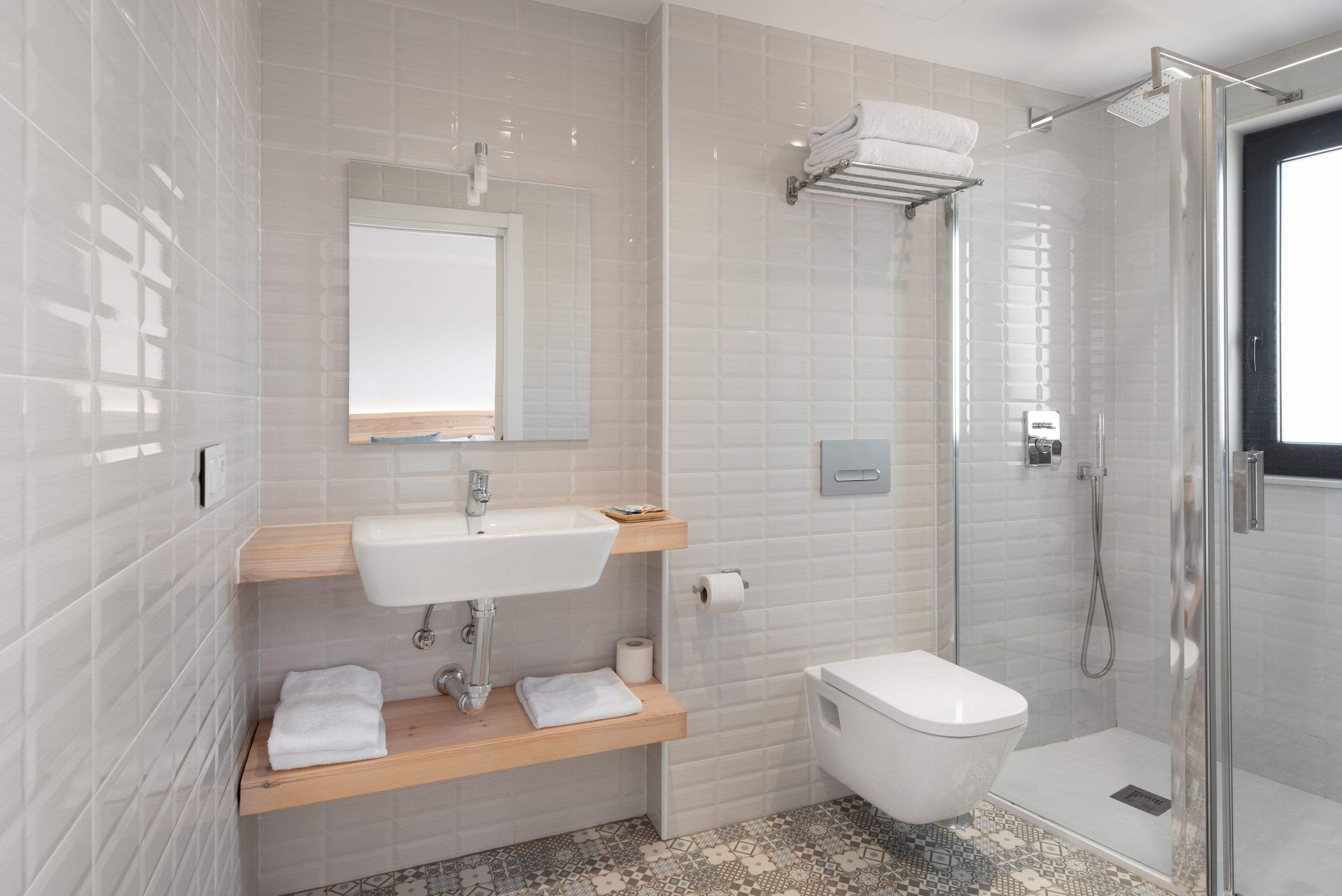 A modern bathroom with a white sink, toilet, and shower.