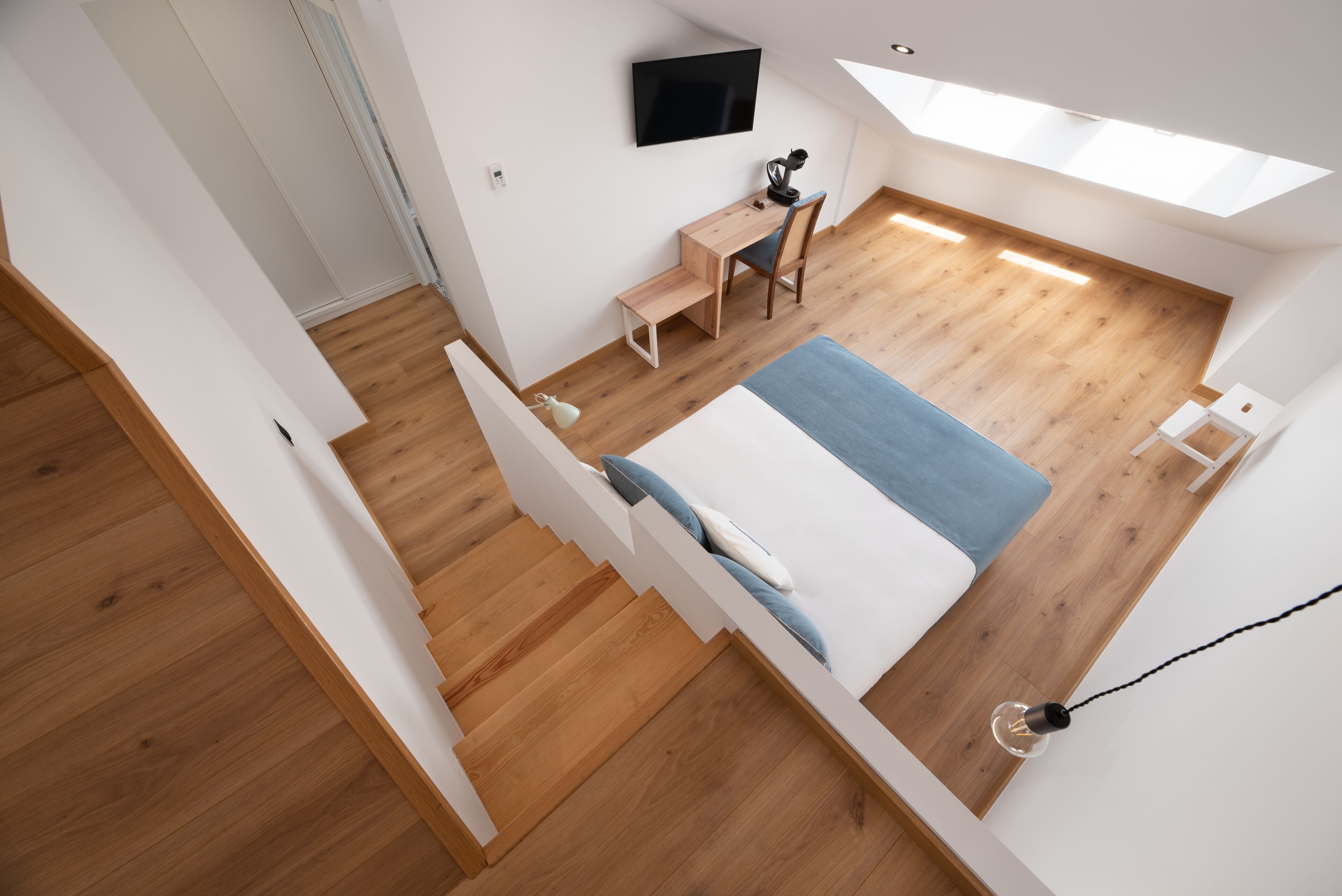 Ein gemütliches Schlafzimmer mit Bett, Schreibtisch und Stuhl.