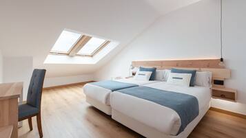 A modern bedroom with a skylight, a bed with a wooden headboard, and a desk with a chair.