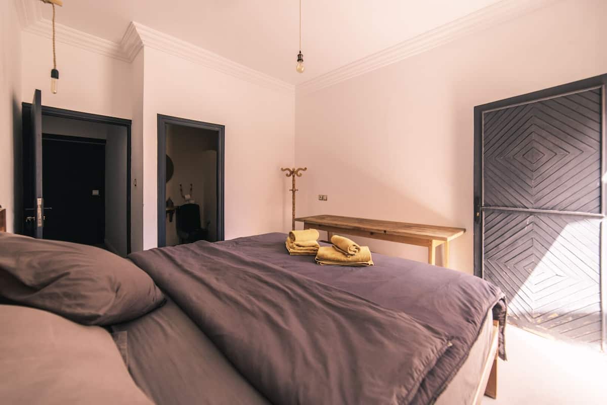 Ein Schlafzimmer mit einem Bett, einer Holzbank und einem Kleiderschrank.