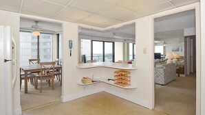 Ein geräumiges Zimmer mit Essbereich, einer integrierten Küchenarbeitsfläche und einer Sitzecke mit Sofa und Lampe.