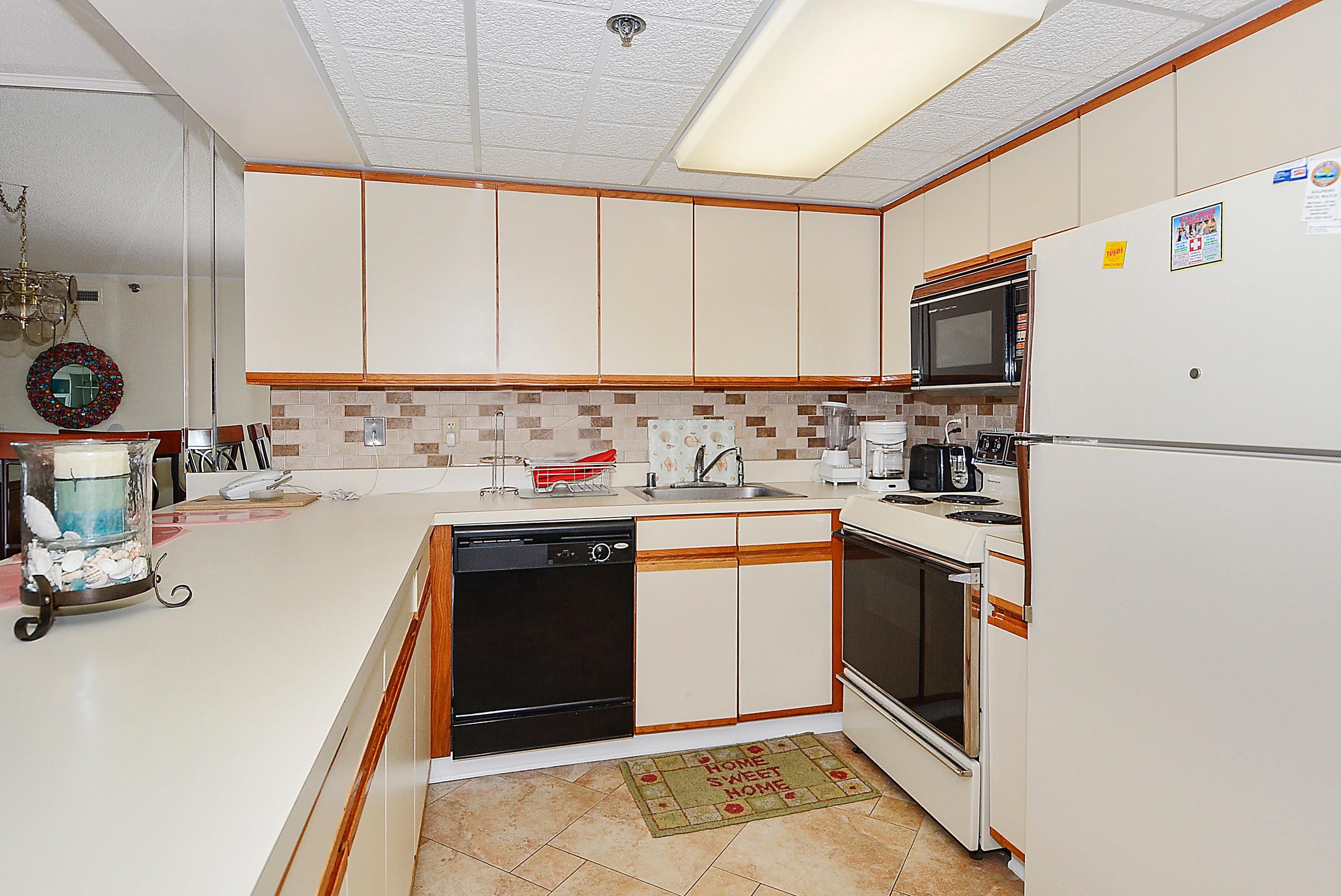 A kitchen with white cabinets, a microwave, a stove, and a dishwasher.