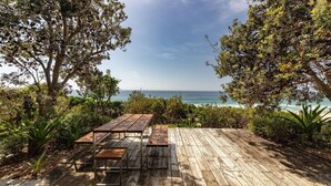 A wooden deck with a table and benches overlooking a beach. - Barefoot on Blueys - Blueys Beach (Blueys Beach)