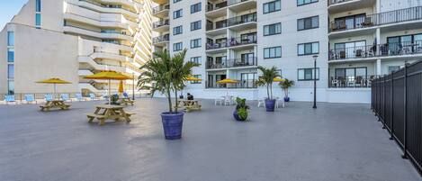 Un hotel moderno con varios balcones, zonas de estar al aire libre y plantas en macetas.