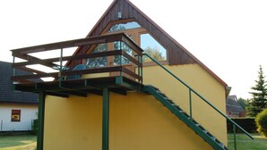 A yellow building with a wooden staircase and a balcony. - Apartment morning sun (Pruchten)