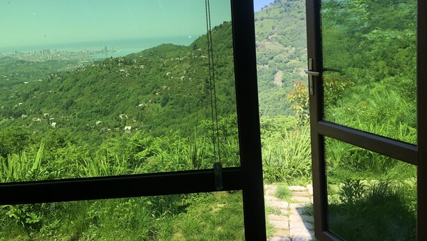 A view from a window overlooking a lush green landscape with a city in the distance. - Eco-flat camping in mountain (Batumi)