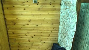 A small, wooden room with a single bed, a nightstand, and a curtain. - Eco-flat camping in mountain (Batumi)
