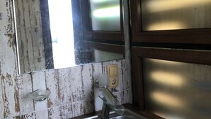 A rustic bathroom with a wooden vanity, a single sink, and a mirror. - Eco-flat camping in mountain (Batumi)