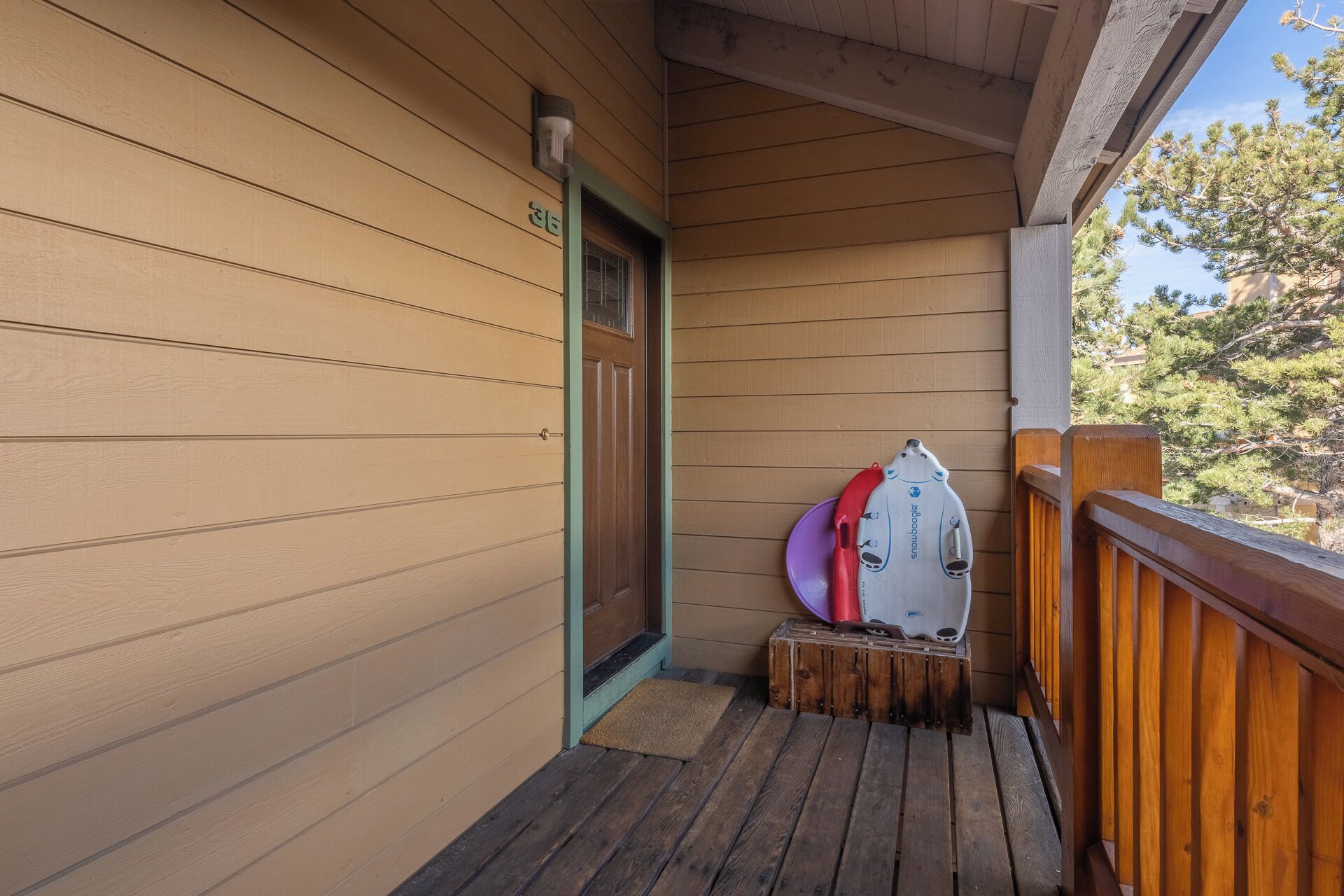 Fachada de madera con una puerta y un pequeño porche.