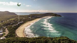 A coastal area with a beach, ocean, and hills.