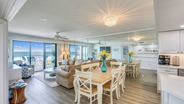 A spacious living area with a dining table, sofas, and a view of the ocean. - DAILY ACTIVITIES & LINENS INCLUDED*! Direct oceanfront 2BR/2BA with enclosed den (used as 3rd bedroom). (Ocean City)