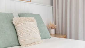 A bed with green pillows and a textured white throw blanket. - Banksia - Pacific Palms Holidays (Blueys Beach)