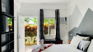 Un dormitorio con cama, escritorio y aire acondicionado.