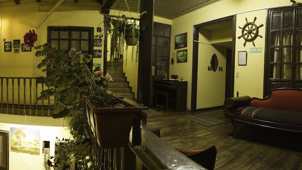 Un interior de diversos nivells amb baranes de fusta, una escala, un sofà i una decoració de timó de vaixell.
