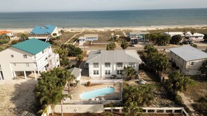 Una propiedad frente a la playa con varias construcciones, una piscina y vista al océano.