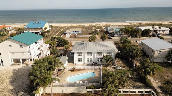 Una propiedad frente a la playa con varias construcciones, una piscina y vista al océano.