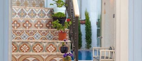 A staircase with patterned tiles and potted plants.