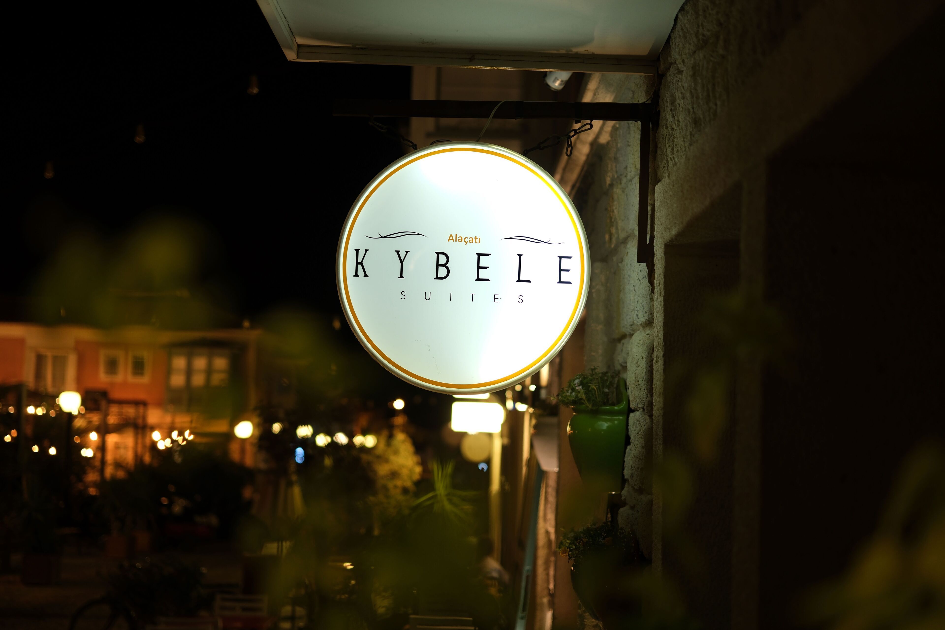 A sign for "Kybelle Suites" with a circular design and illuminated text.