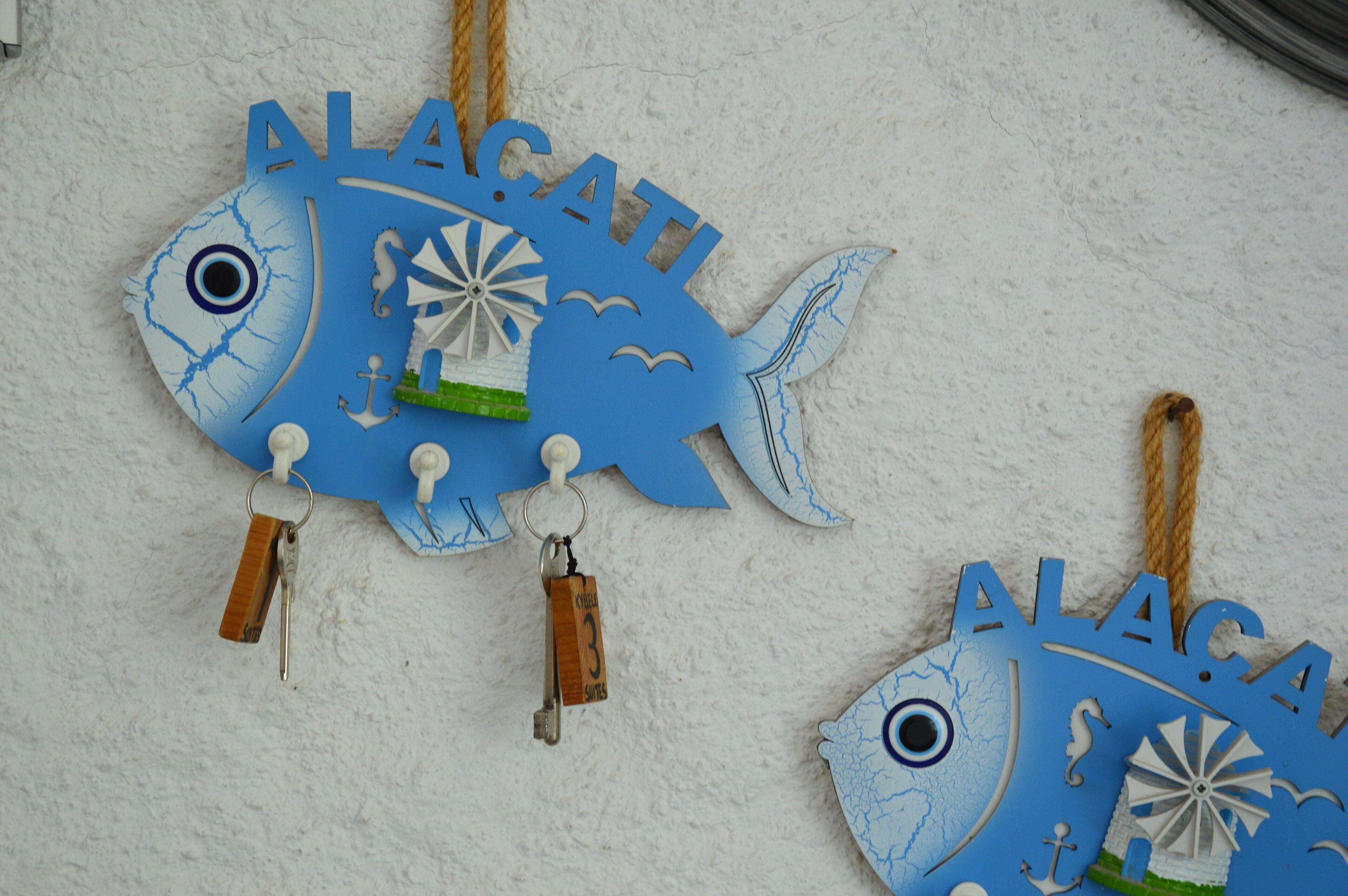 Two blue fish-shaped decorations with the name "ALACA" hanging from them.