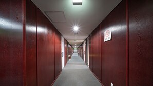 A long, narrow hallway with wooden walls and a carpeted floor. - Hotel Sun (Takasaki)