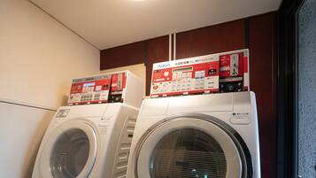 Two front-loading washing machines stacked on a platform with a wooden floor.
