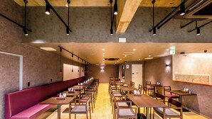 A spacious indoor area with multiple tables and benches, wooden flooring, and ceiling lights. - Hotel Sun (Takasaki)