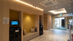 A modern hotel lobby with a reception desk, seating area, and a fire extinguisher. - Hotel Sun (Takasaki)