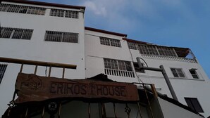 Un edifici amb un rètol que diu "ERIKS HOUSE" i diverses finestres amb reixes.